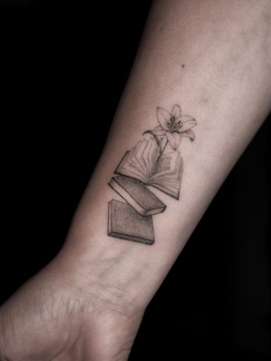 Microrealism fineline books and lily tattoo on wrist, done in Lörrach by vegan tattoo artist Jannine Stefanov