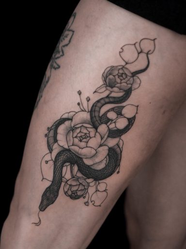 illustrative snake and peony flowers tattoo on thigh, done in Lörrach
