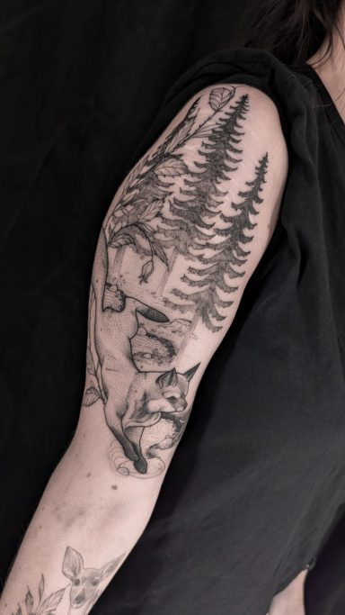 freehand illustrative fox and forest tattoo on upper arm, done in Lörrach by vegan tattoo artist Jannine Stefanov