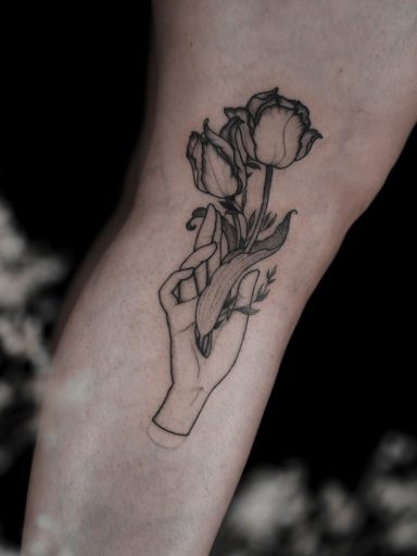 illustrative hand with tulip flower tattoo on leg, done in Lörrach by vegan tattoo artist Jannine Stefanov