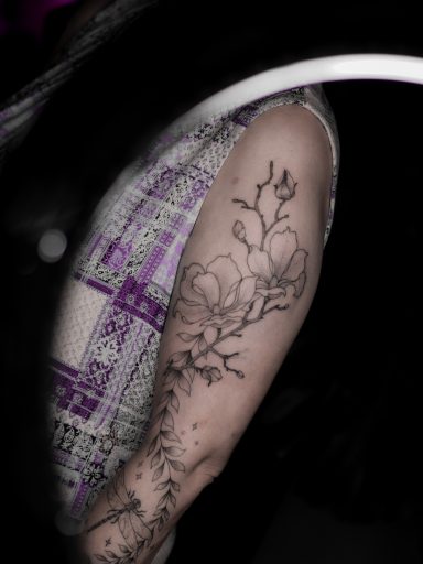 freehand botanical fineline tattoo, magnolias on upper arm, done in Lörrach by vegan tattoo artist Jannine Stefanov