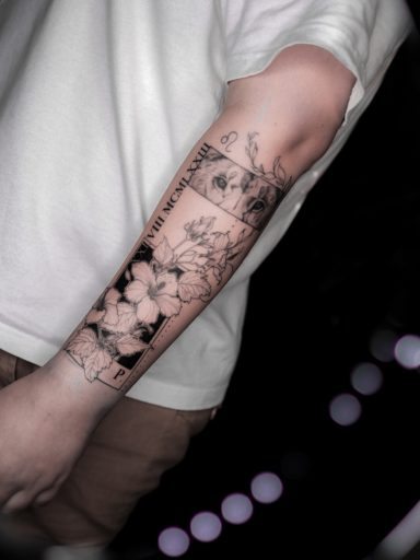 microrealism tattoo with lion, hibiscus flowers and date on forearm, done in Lörrach