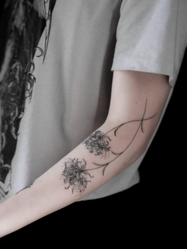 illustrative fineline spider lily flower tattoo on arm, done in Lörrach by vegan tattoo artist Jannine Stefanov